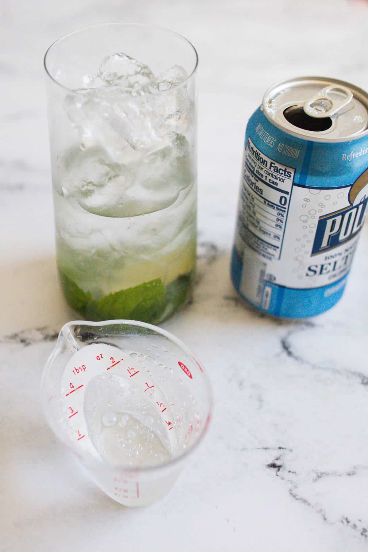 Soda water being measured into a cocktail glass.