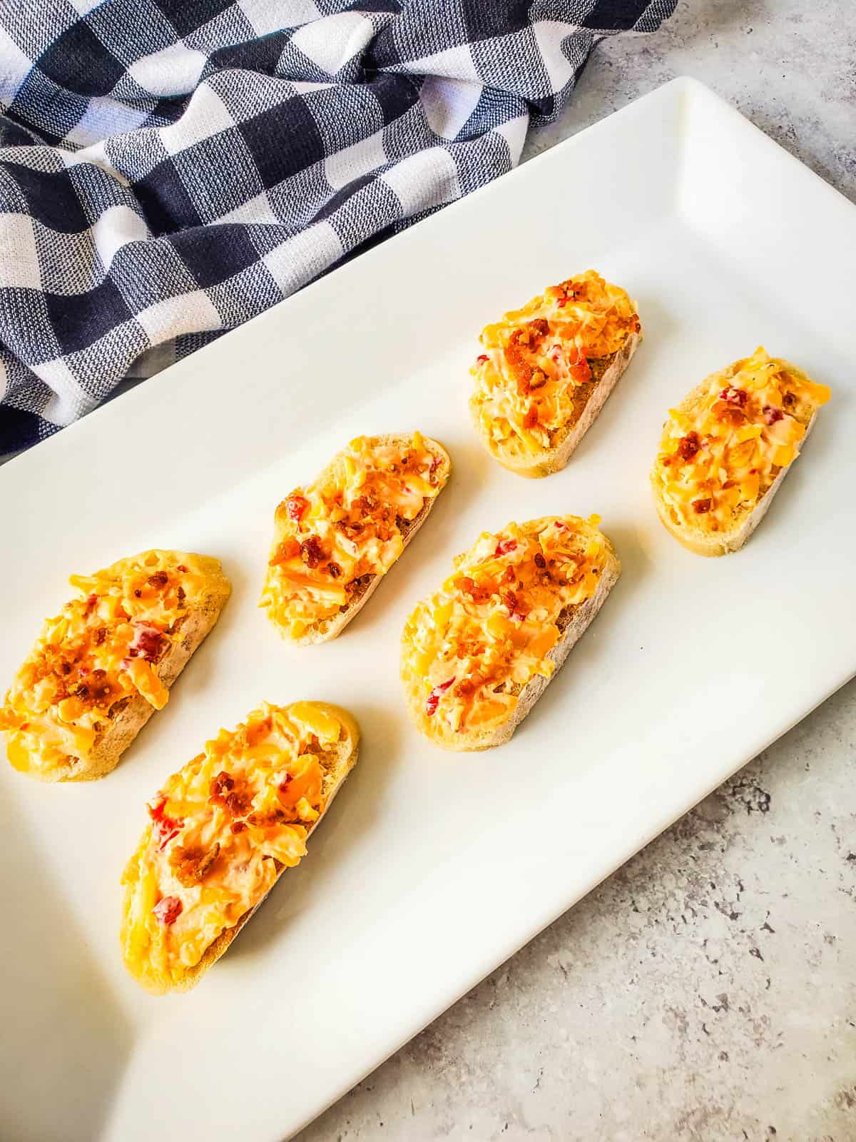 Tasty bacon pimiento cheese crostini on a serving platter.