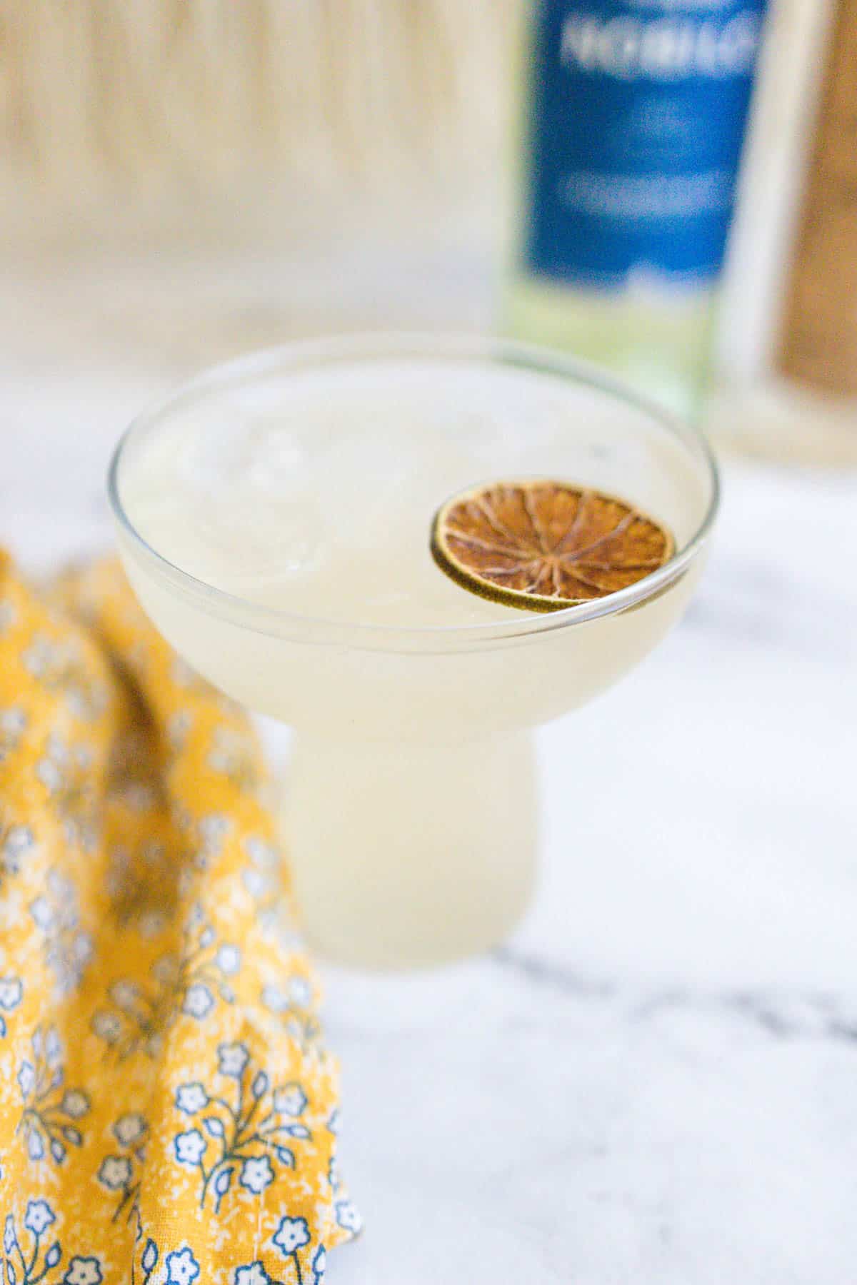 White wine margarita garnished with a dried lime wheel.