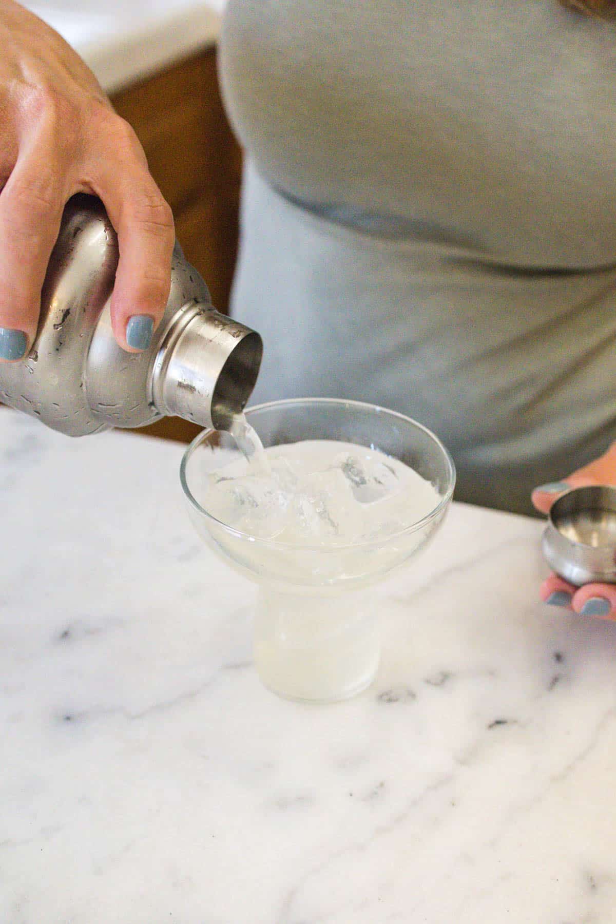 Straining a wine margarita into a margarita glass.