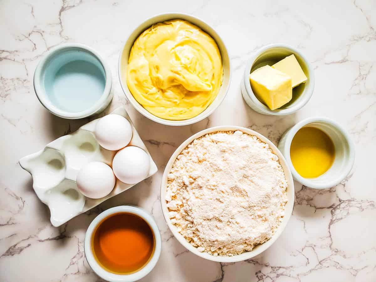 Ingredients needed to make spiced rum cupcakes with boxed cake mix in bowls on a counter.