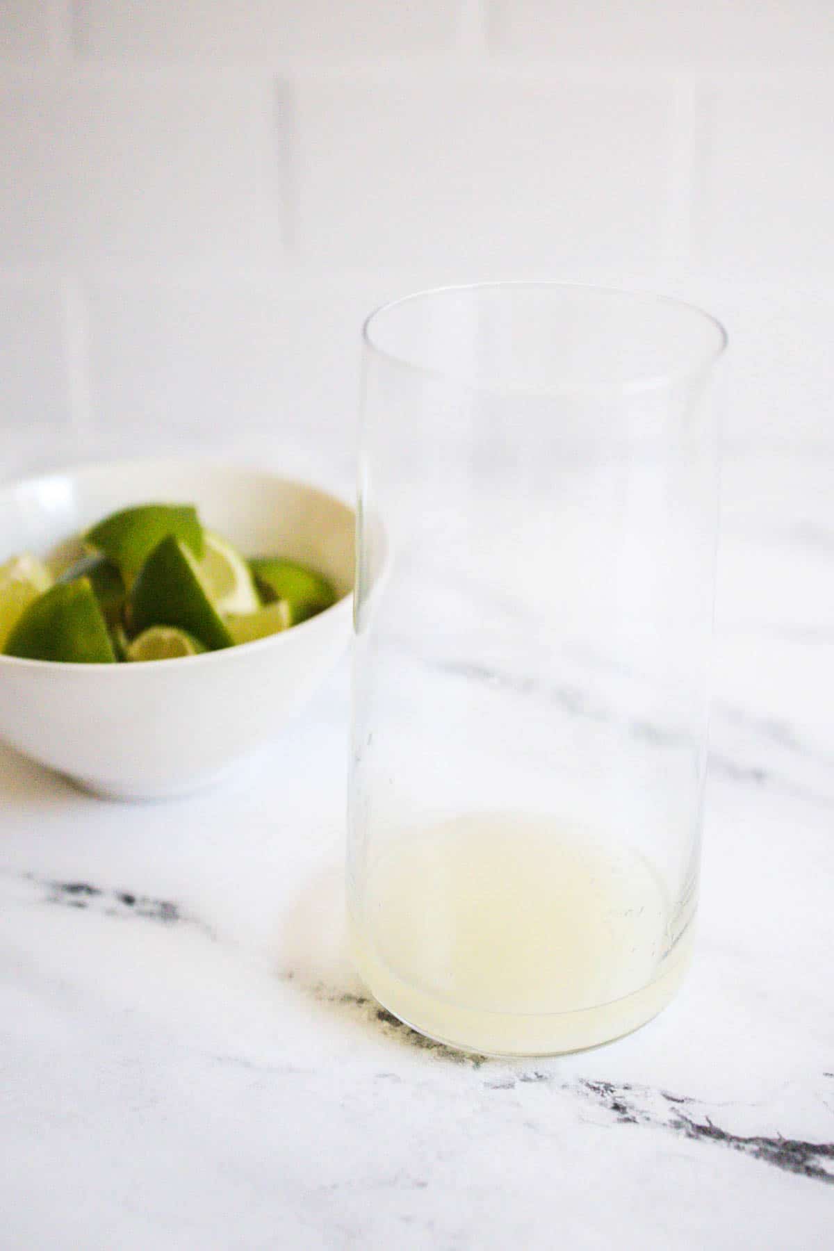 Lime juice in the bottom of a high ball glass.