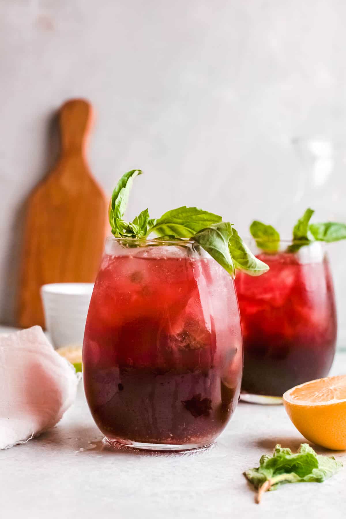 Two cherry Moscow mules garnished with fresh basil.