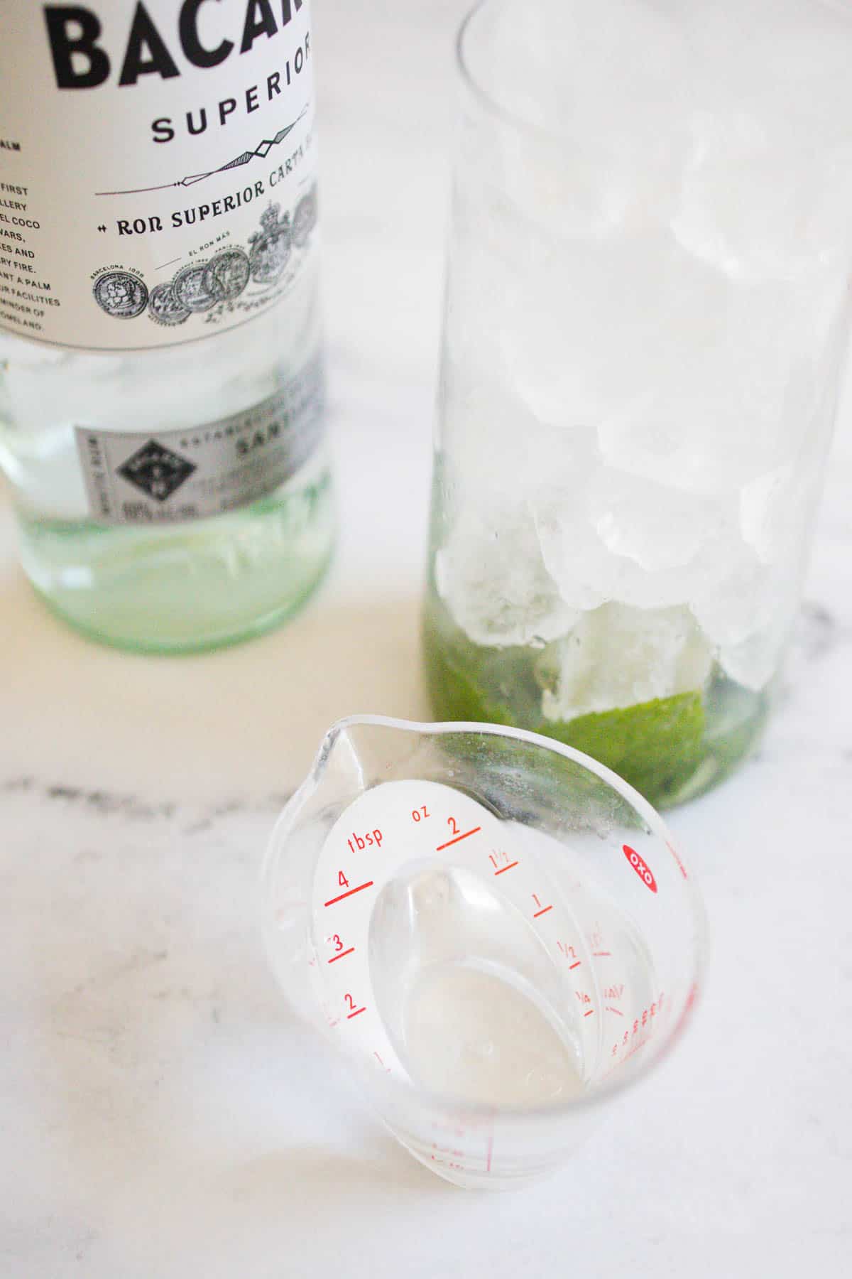 White rum being measured into a cocktail glass.