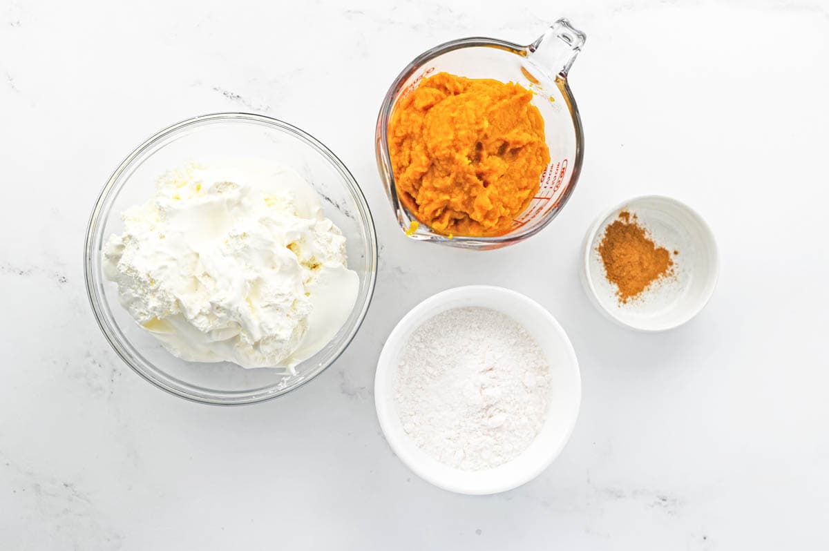 Ingredients in bowls on a counter needed to make pumpkin fluff dessert dip.