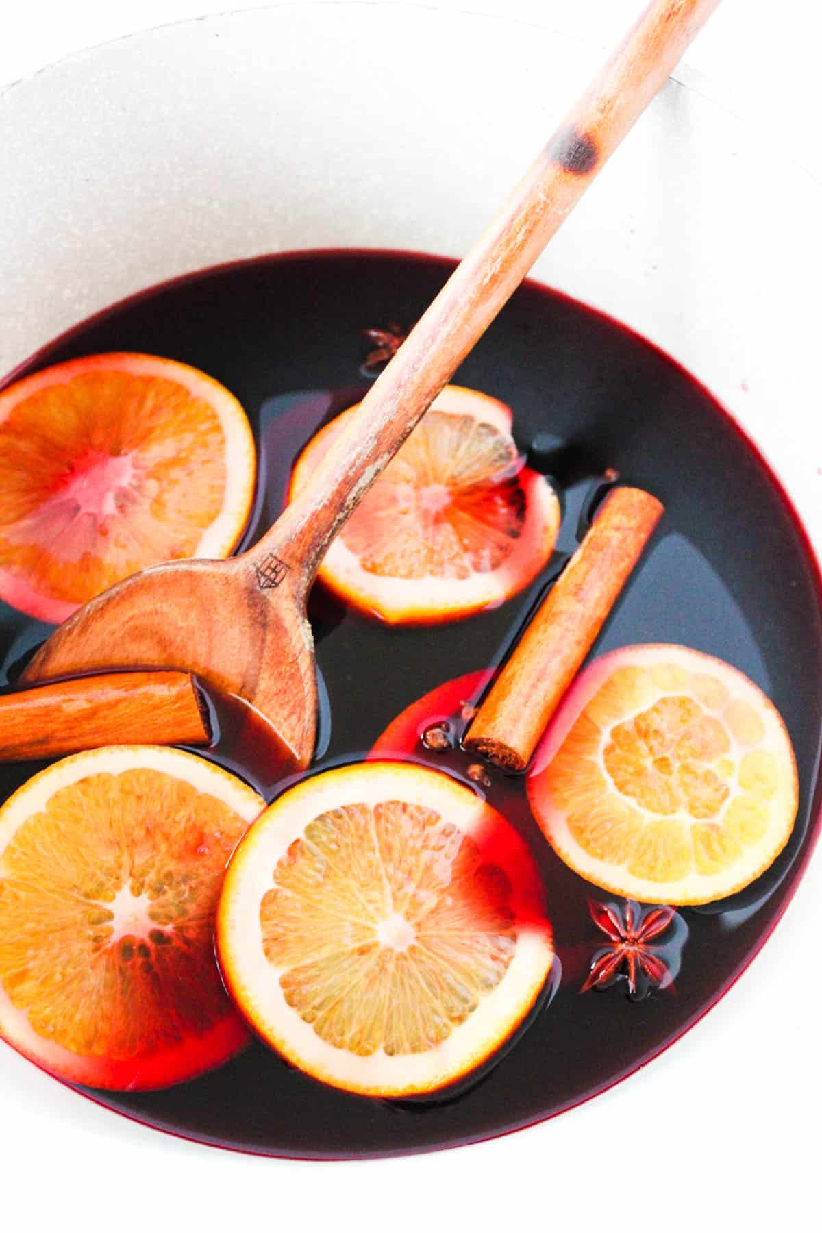 Wooden spoon stirring a pot of mulled wine.