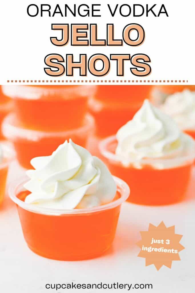Close up of a pair of orange Jello shots topped with whipped cream.