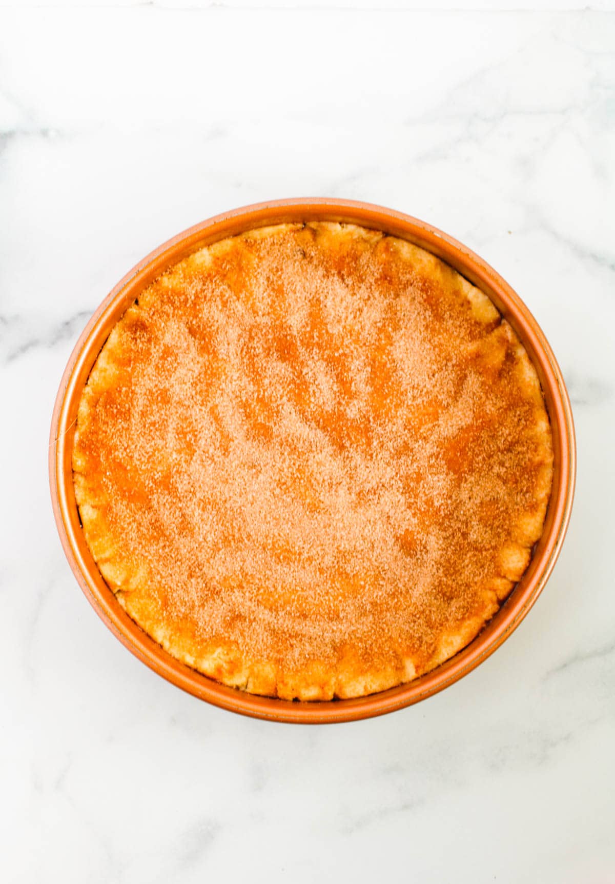 Sugar cookie dough pressed into a cake pan before baking.