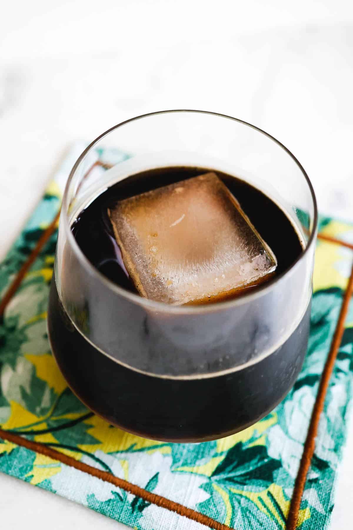 Glass of iced coffee with an ice cube.