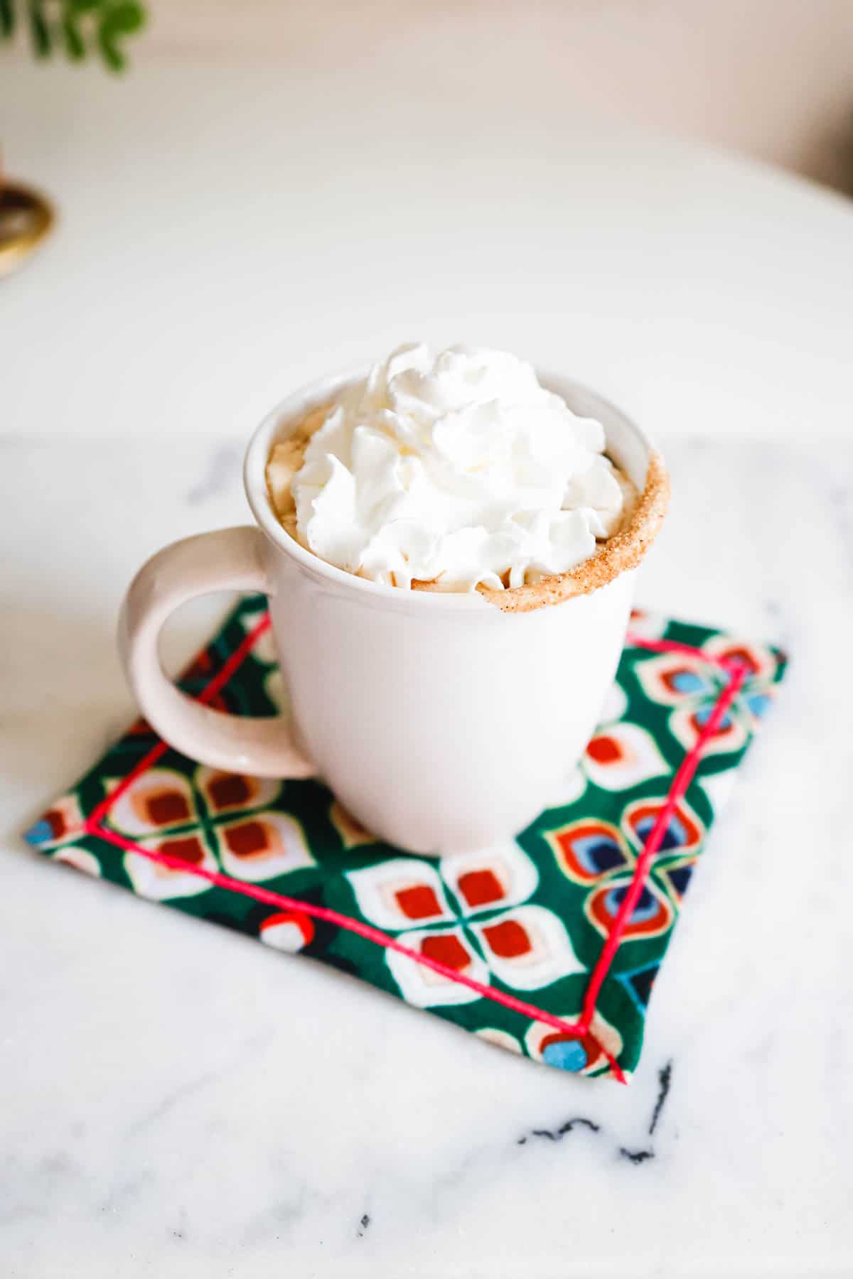Mug of amaretto coffee topped with whipped cream and cinnamon.