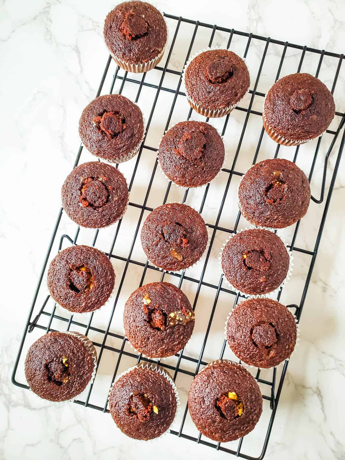 Snickers cupcakes with the middle of each cupcake filled with peanut caramel filling.