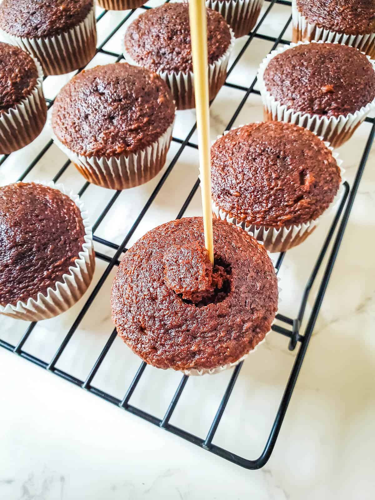 Taking out the middle of the cupcake to be filled with caramel and peanut.