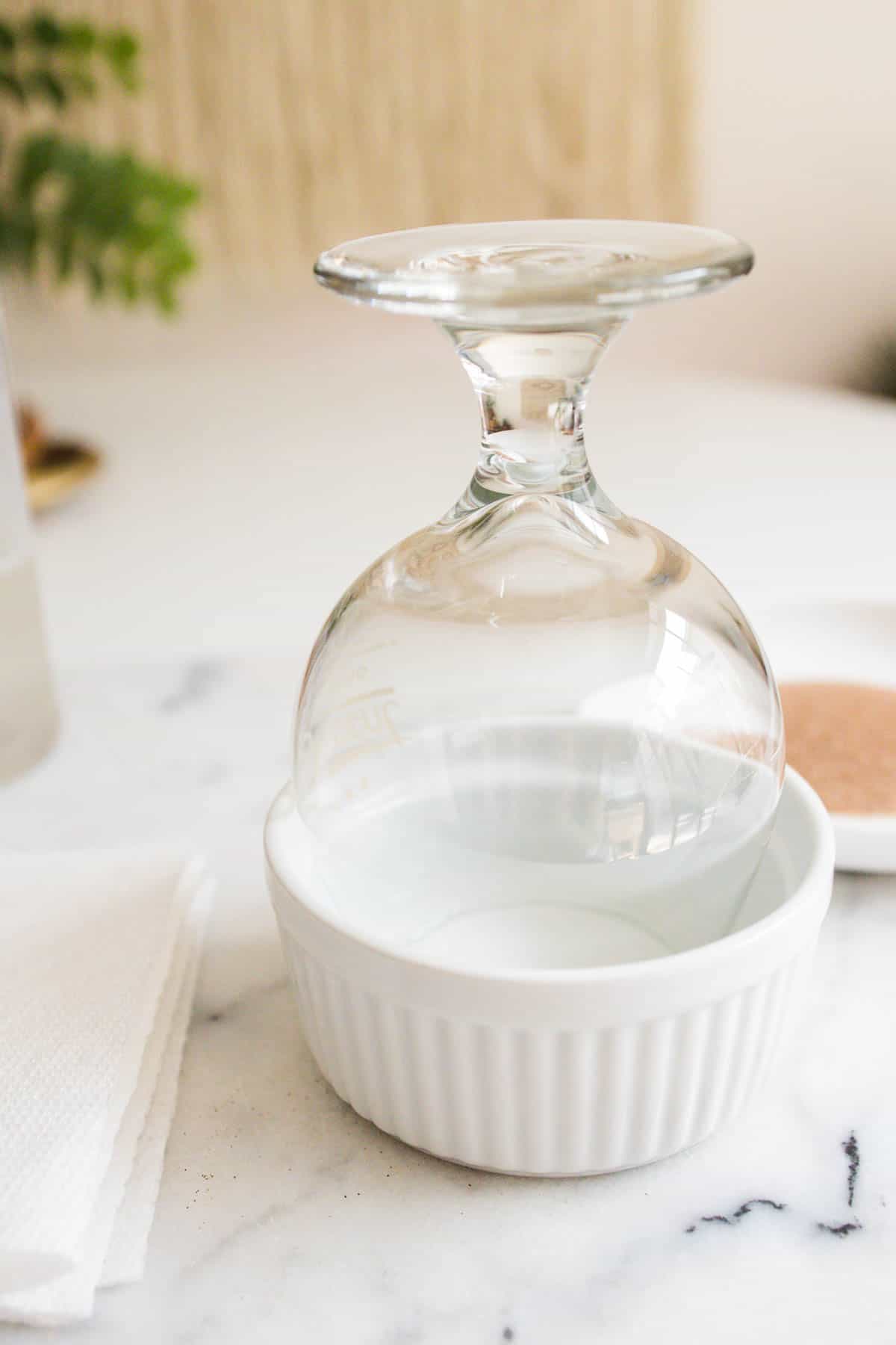 Glass sitting upside down in a white dish.