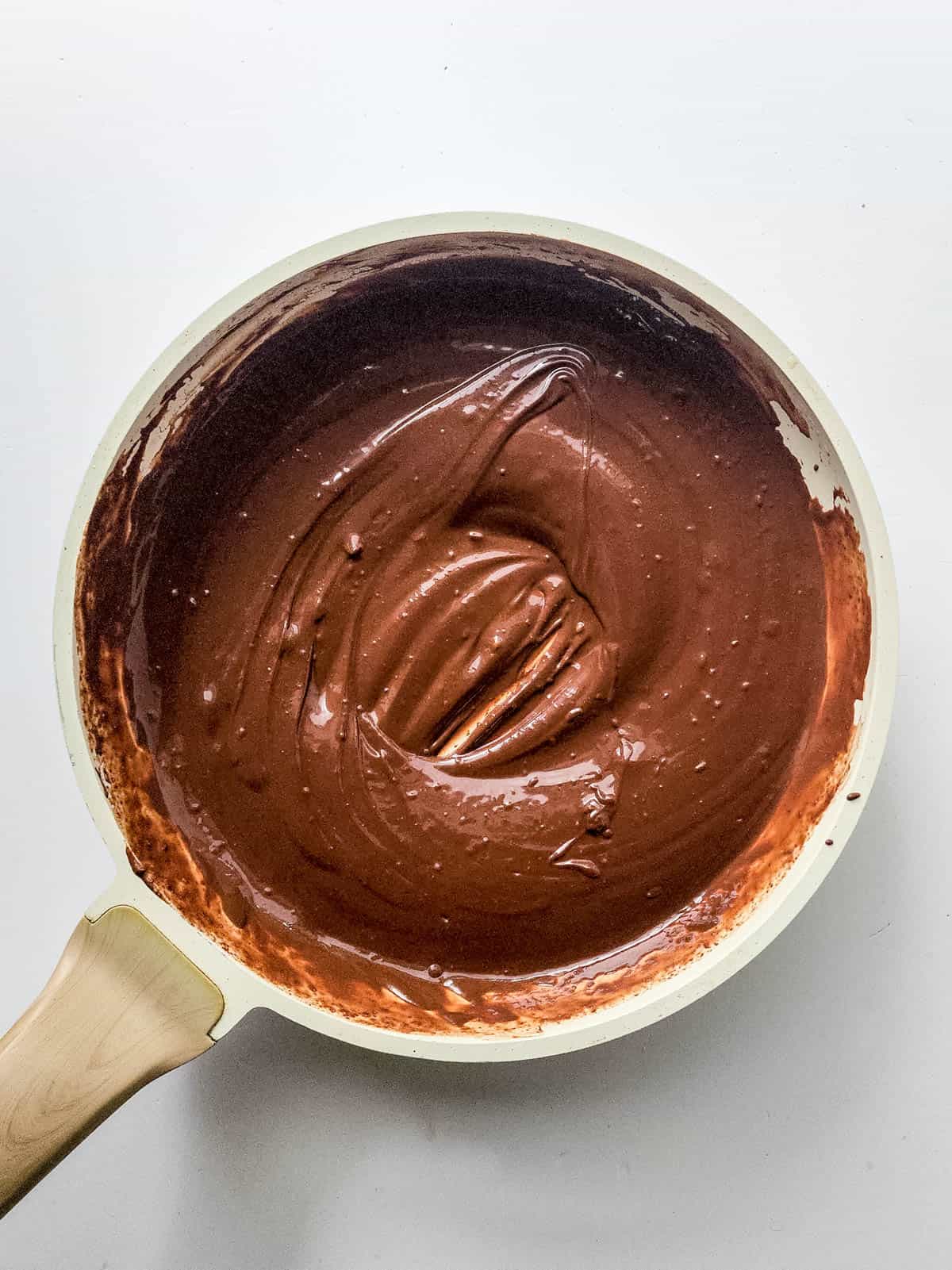 Chocolate mixture for brownie cookies combined in a glass bowl.