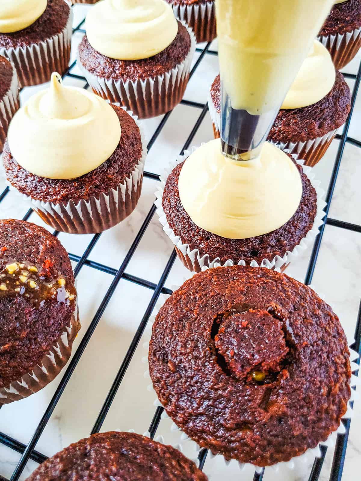 Frosting snickers cupcakes with caramel butterscotch frosting.