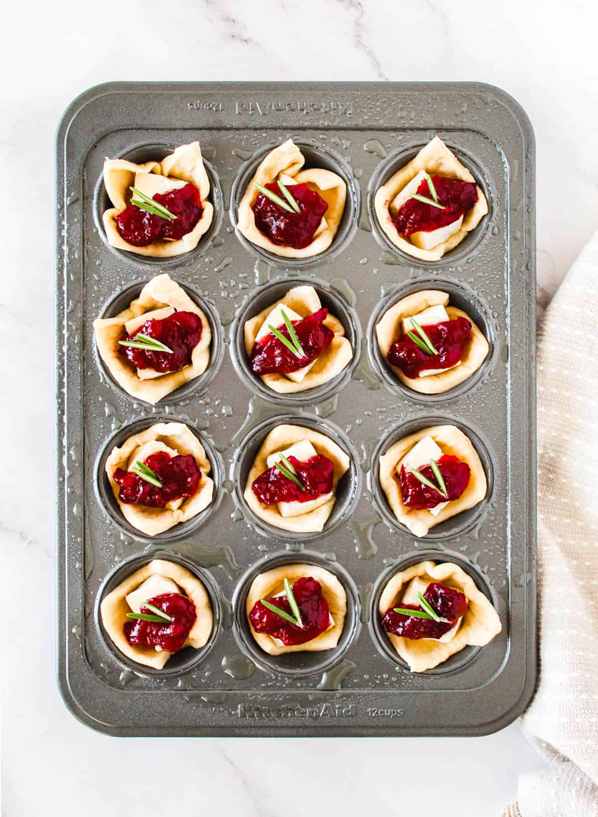 Brie cranberry bites assembled in a mini muffin tin.