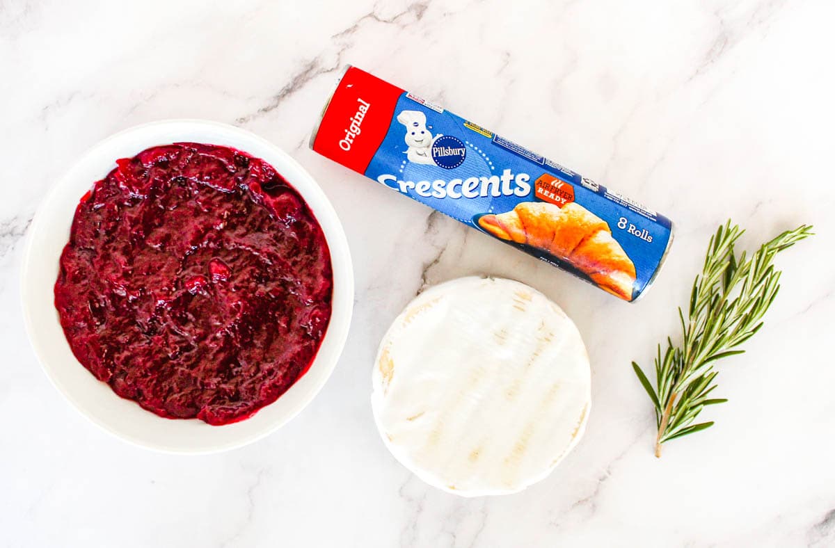 Whole berry cranberry sauce, crescent roll, fresh thyme, and brie cheese, ingredients needed to make cranberry brie bites.