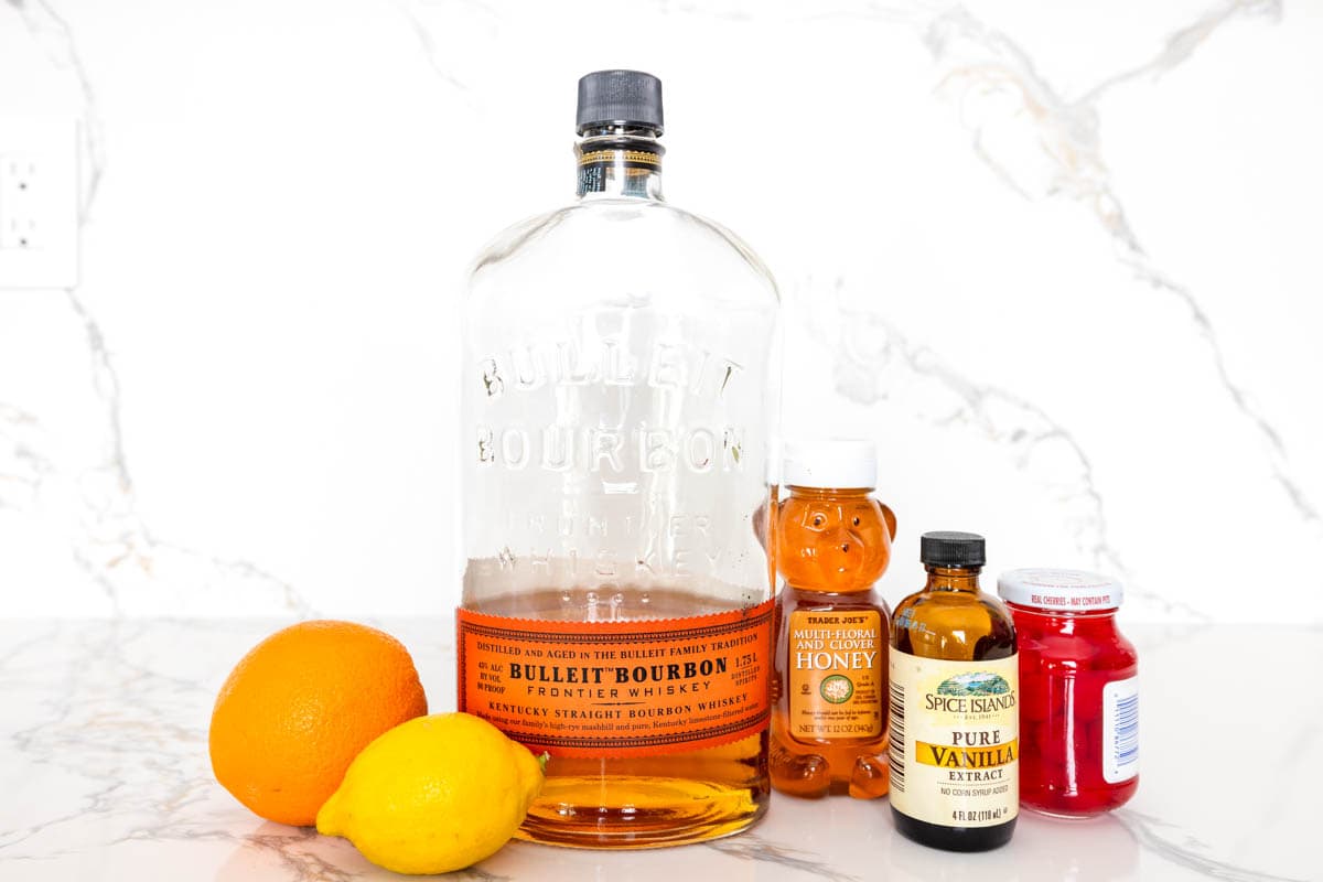 Lemon Honey Whiskey Sour ingredients on a marble countertop.