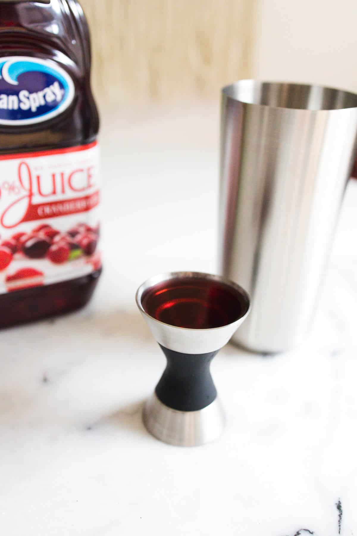 Jigger filled with cranberry juice.