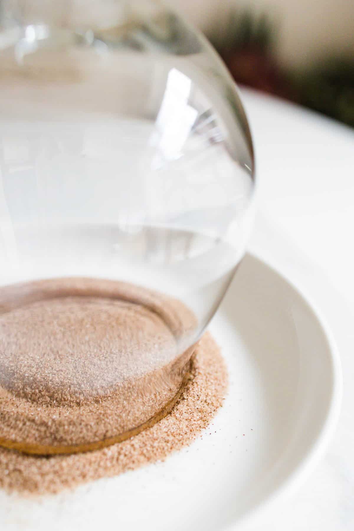 Glass upside down in a dish of cinnamon sugar.