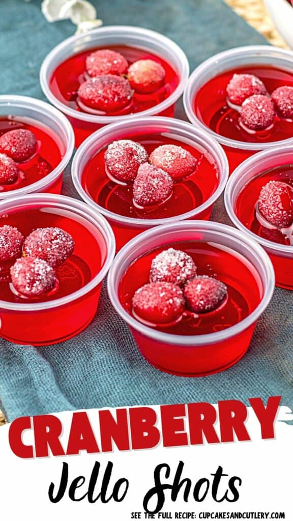 Text: Cranberry Jello Shots with a close up of red vodka jello shots topped with sugared cranberries.