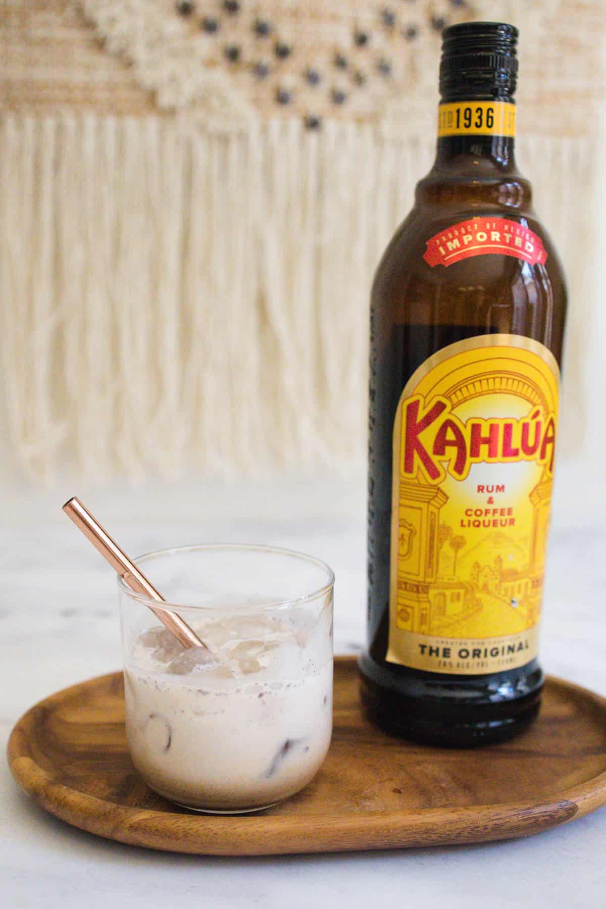 Kahlua and Cream cocktail next to a bottle of Kahlua.
