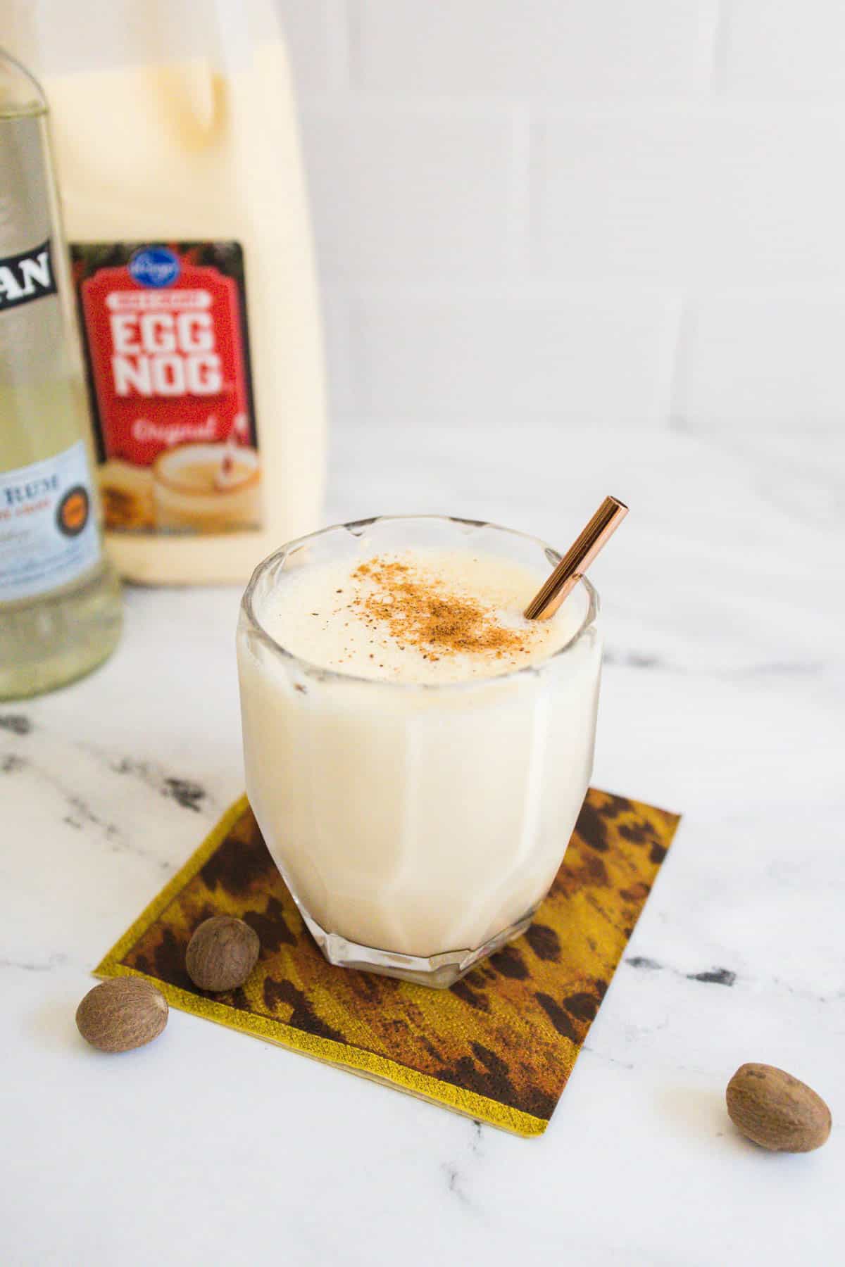 Eggnog daiquiri with the bottles of rum and eggnog in the background.