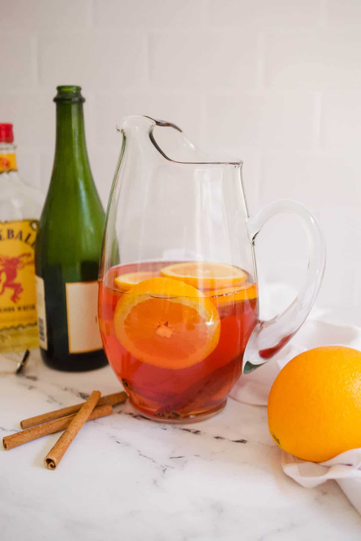 Pitcher of Fireball Sangria with the ingredients in the background.