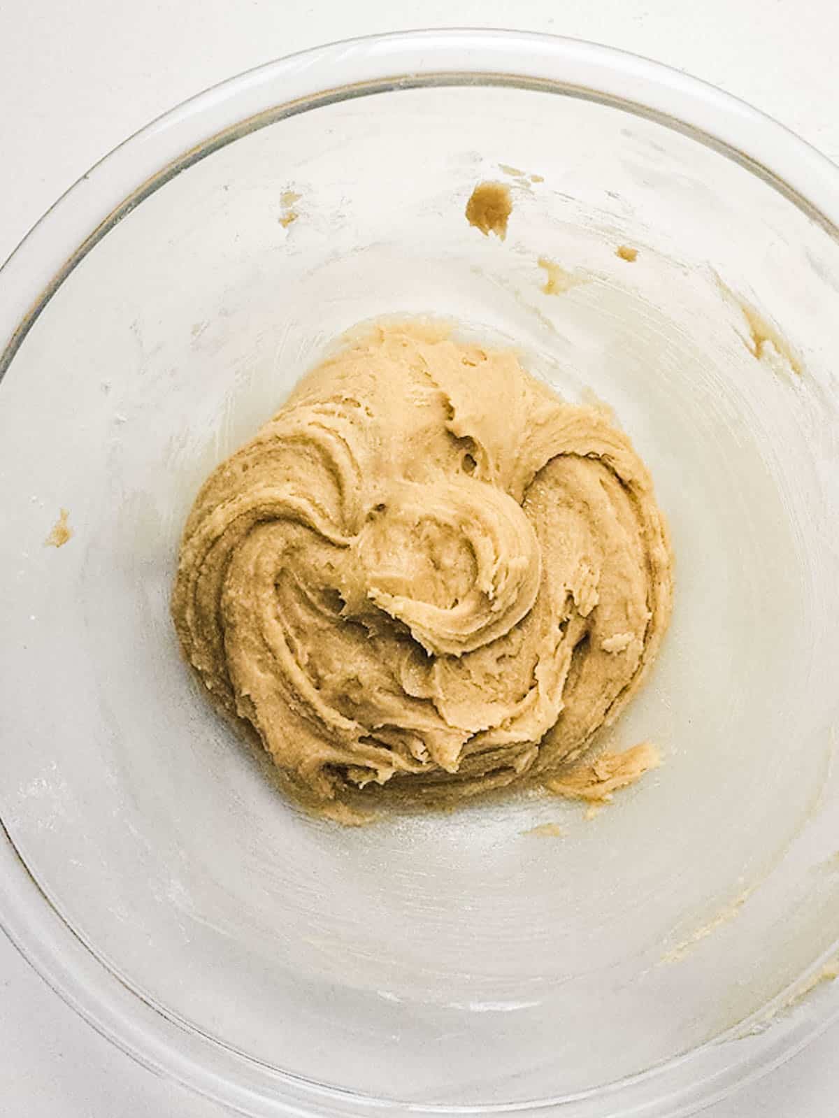 White chocolate cookie dough in a glass mixing bowl.