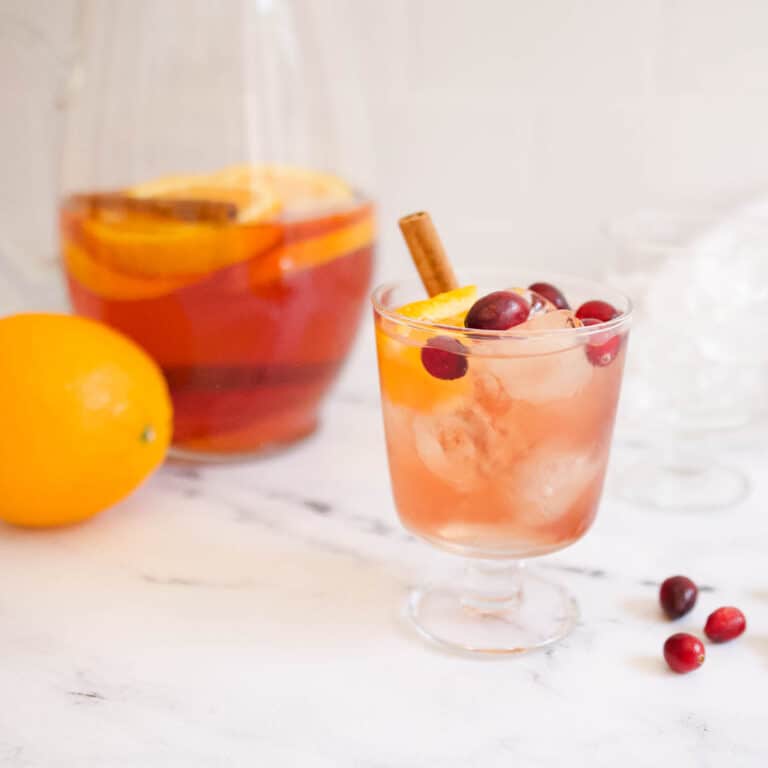 Close up of a cranberry and orange sangria in a short wine glass.