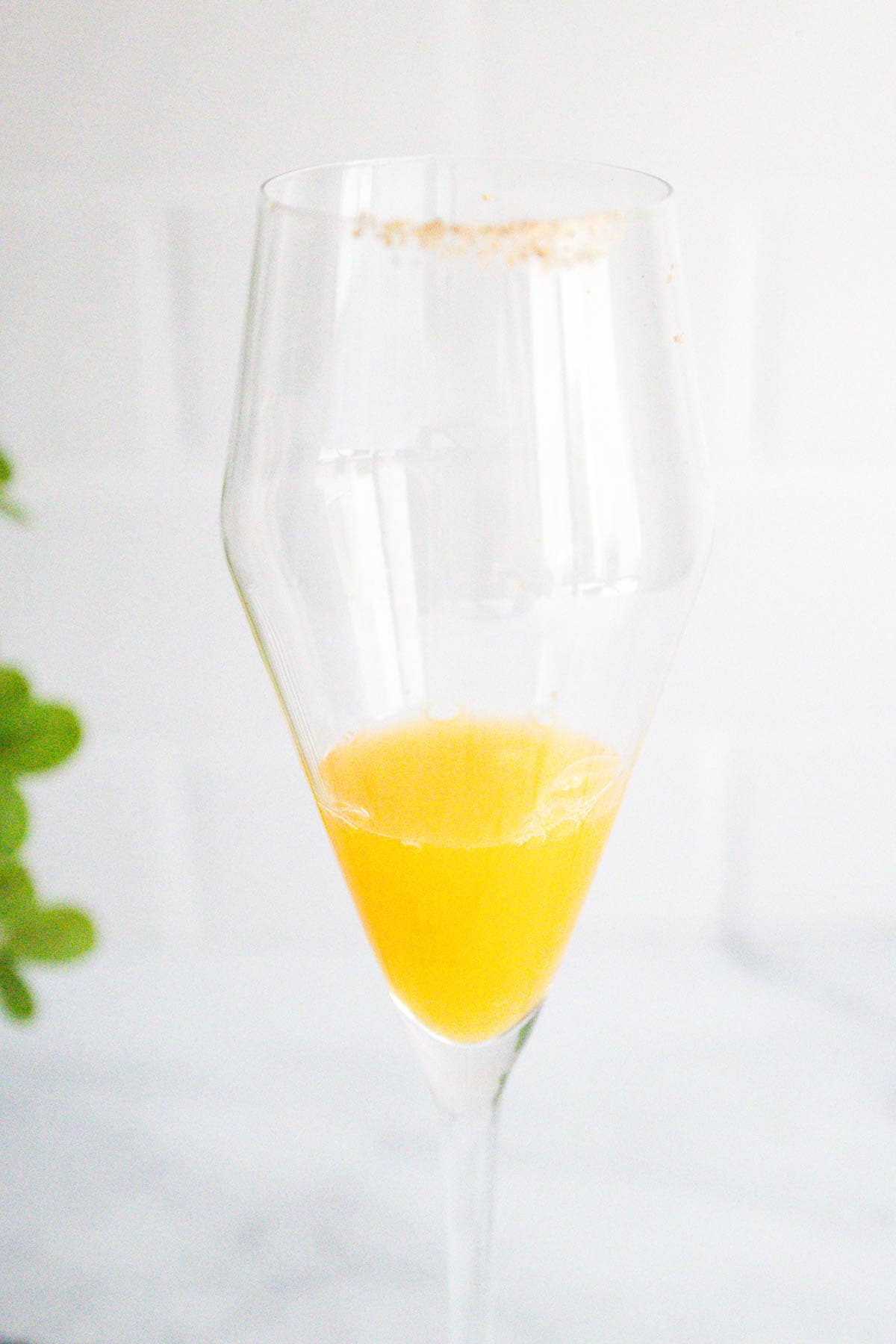 Orange juice in the bottom of a champagne flute.