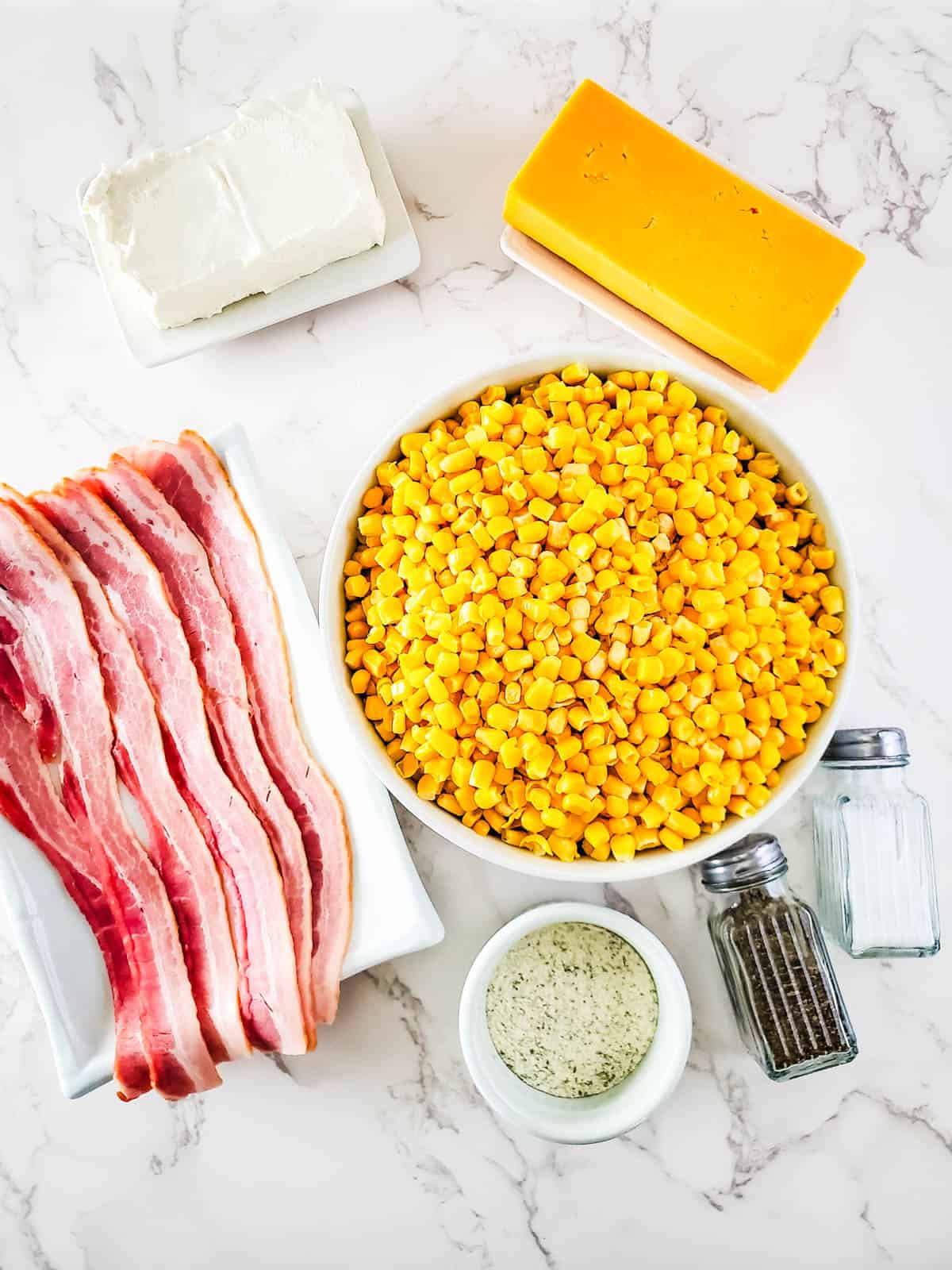 Ingredients to make creamed corn with cream cheese and bacon in a crockpot.