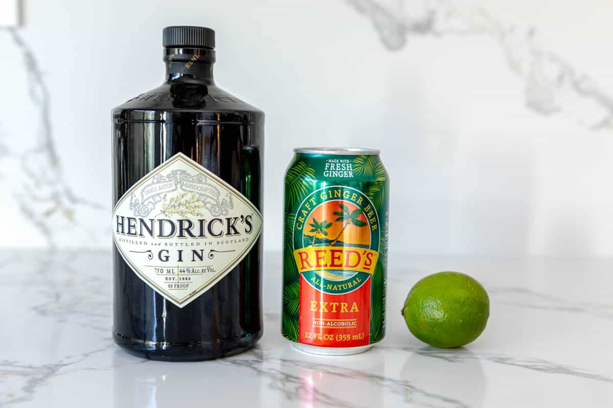 Ingredients for a Gin Mule on a white marble countertop.