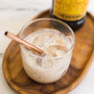 Close up of a glass of Kahlua and Cream with a metal straw.