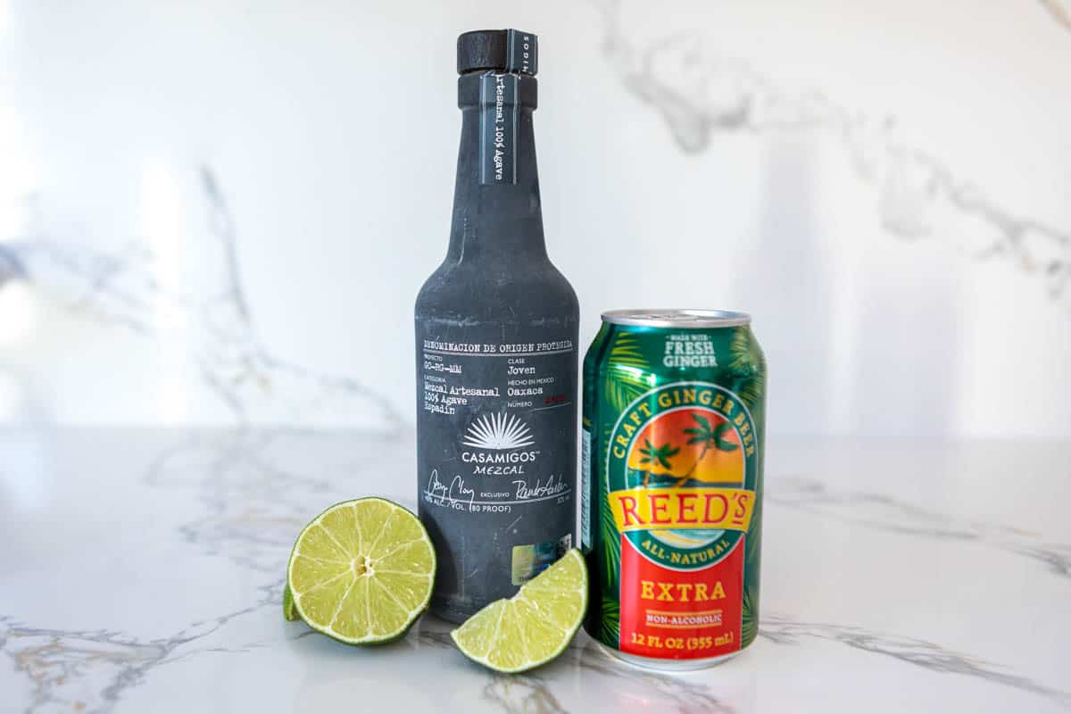 Mezcal Mule ingredients on a white marble countertop.