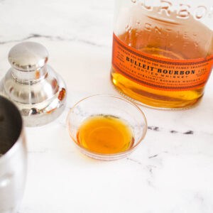 A small glass dish holding a shortcut honey simple syrup that has been made in the microwave.