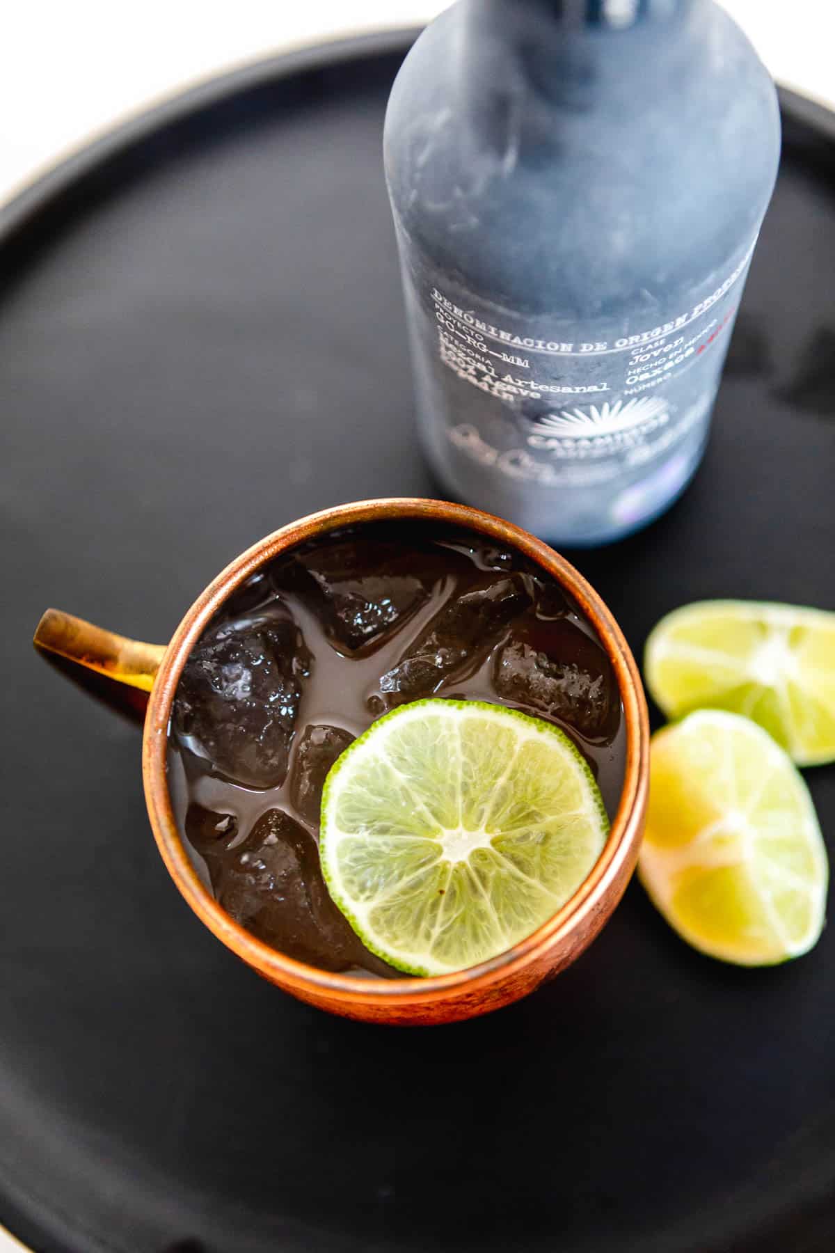 Overhead shot of a mezcal mule in a copper mug garnished with a lime wheel.