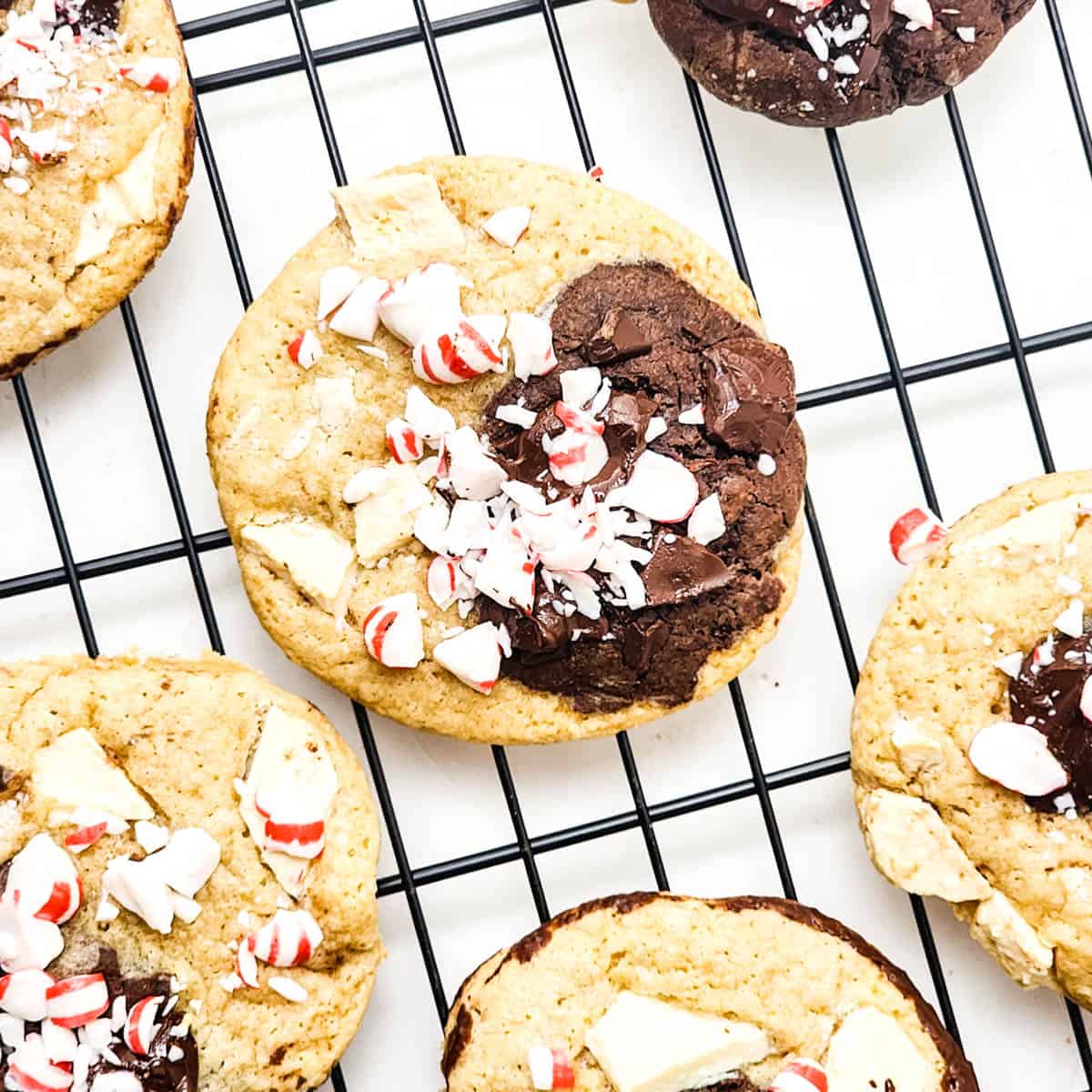 Delicious marbled cookies with dark and white chocolate flavors topped with crushed peppermint candy on a wire rack.