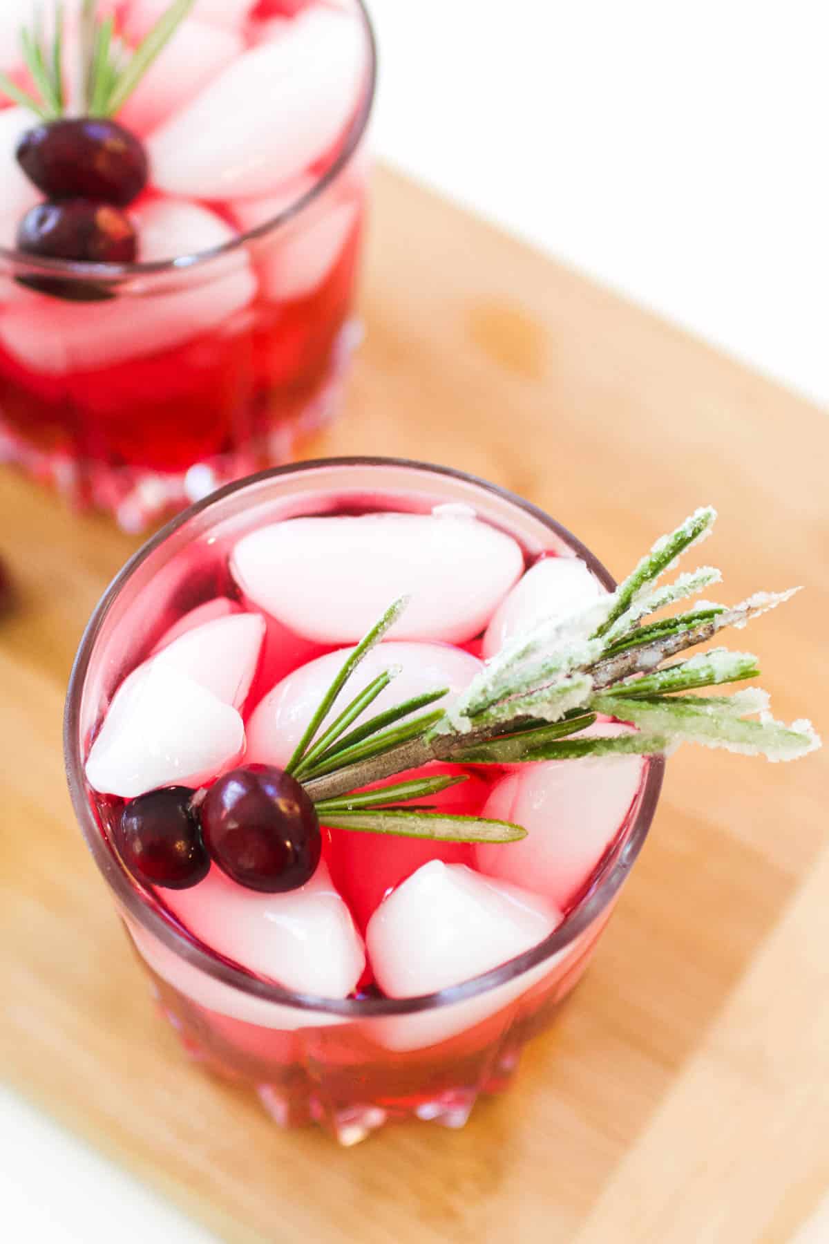 A couple of drinks garnished with sugared rosemary sprigs.