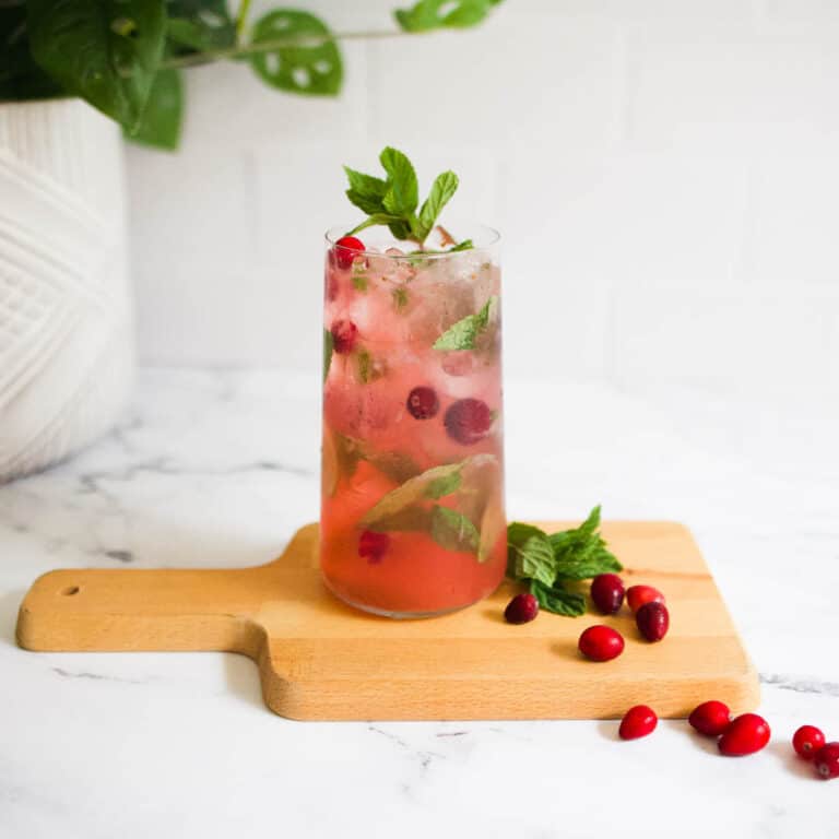 Cranberry moot on a wooden board with fresh cranberries and mint leaves.