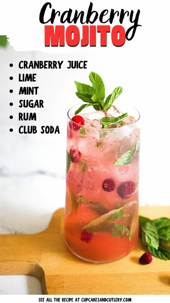 Close up of a cranberry mojito garnished with fresh mint on a wooden cutting board.