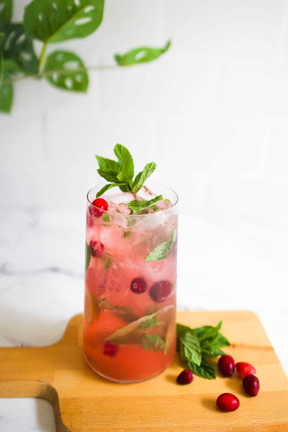 Cranberry mojito recipe Cranberry mojito on a wooden cutting board.