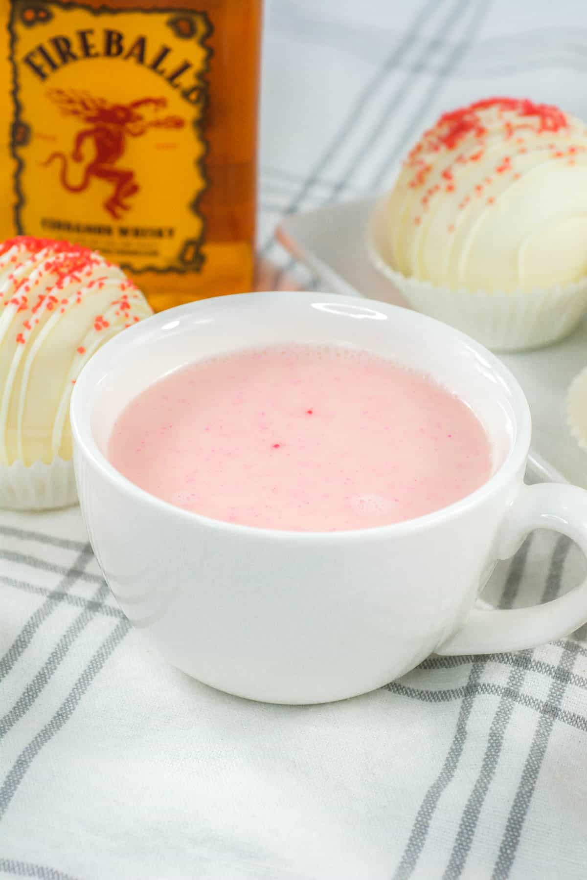 White mug of pink Fireball hot cocoa.