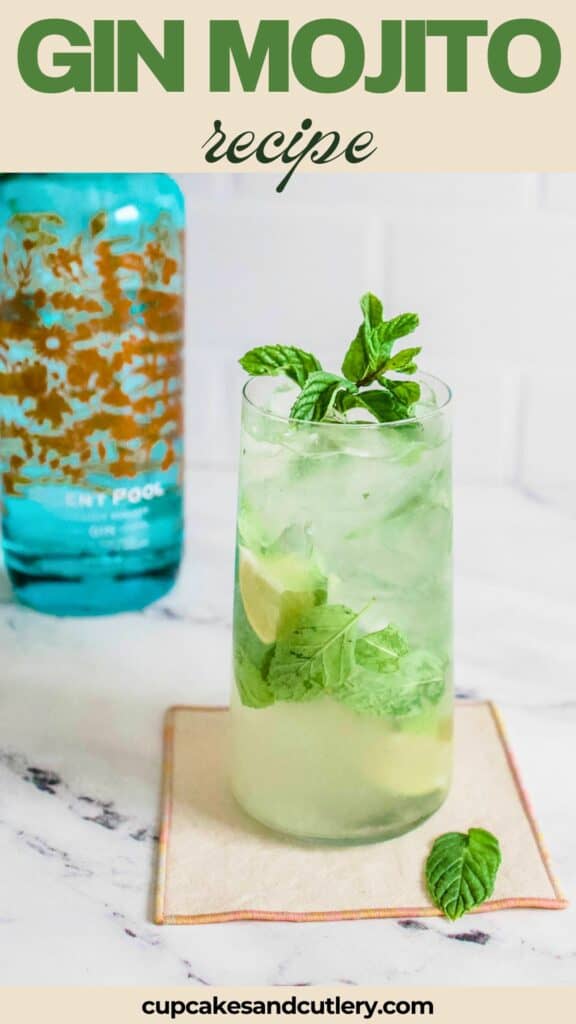 Close up of a mojito with a bottle of gin in the background.