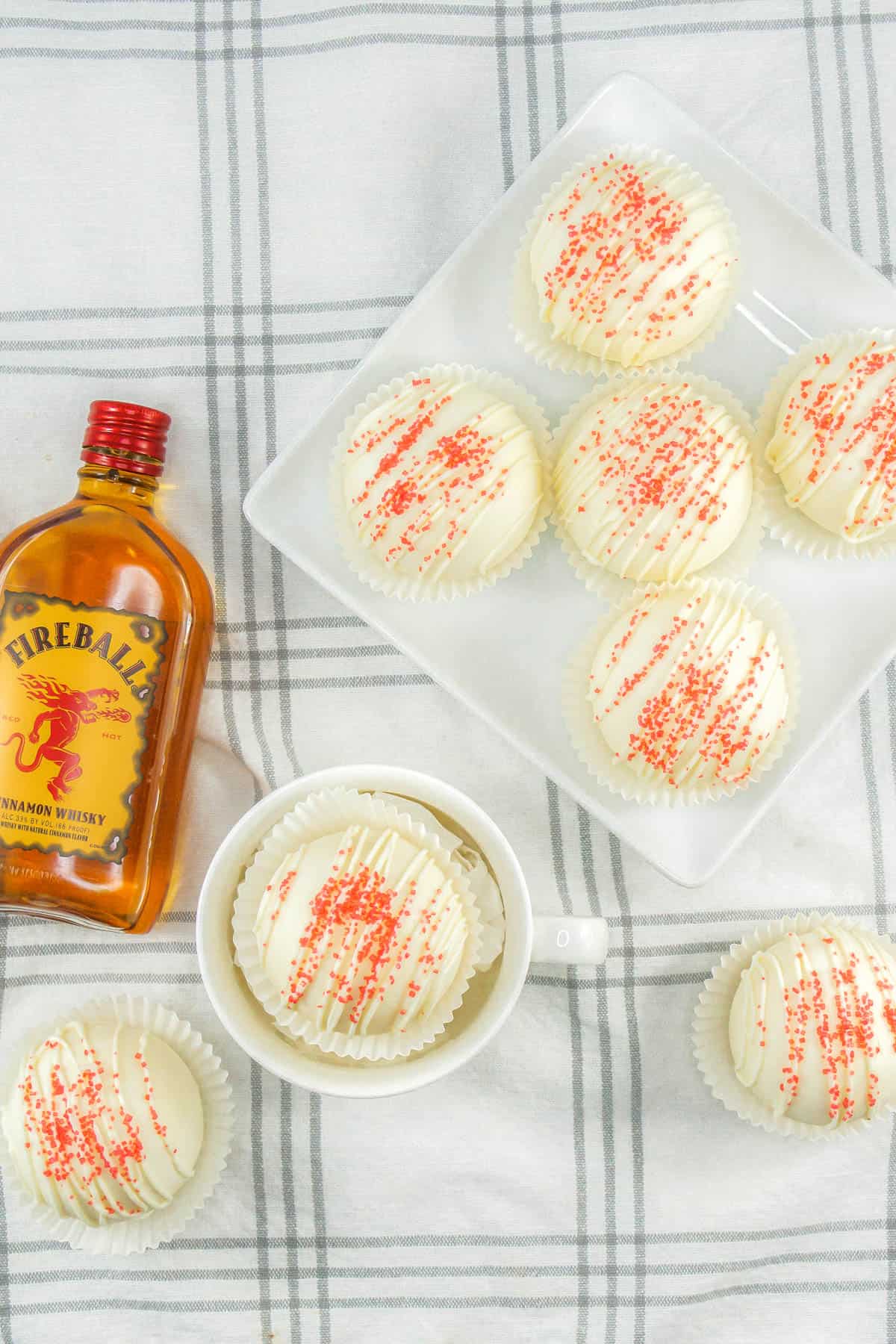 Fireball hot coca bombs on a white plate with a small bottle of Fireball.