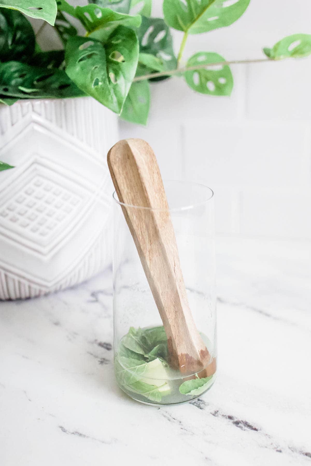 gin lime muddled Gin, lime and mint being muddled in a glass.