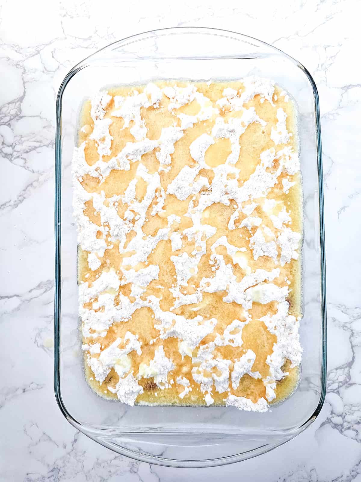 Yellow cake mix sprinkled over the top of the Strawberry cheesecake dump cake with melted butter poured over.