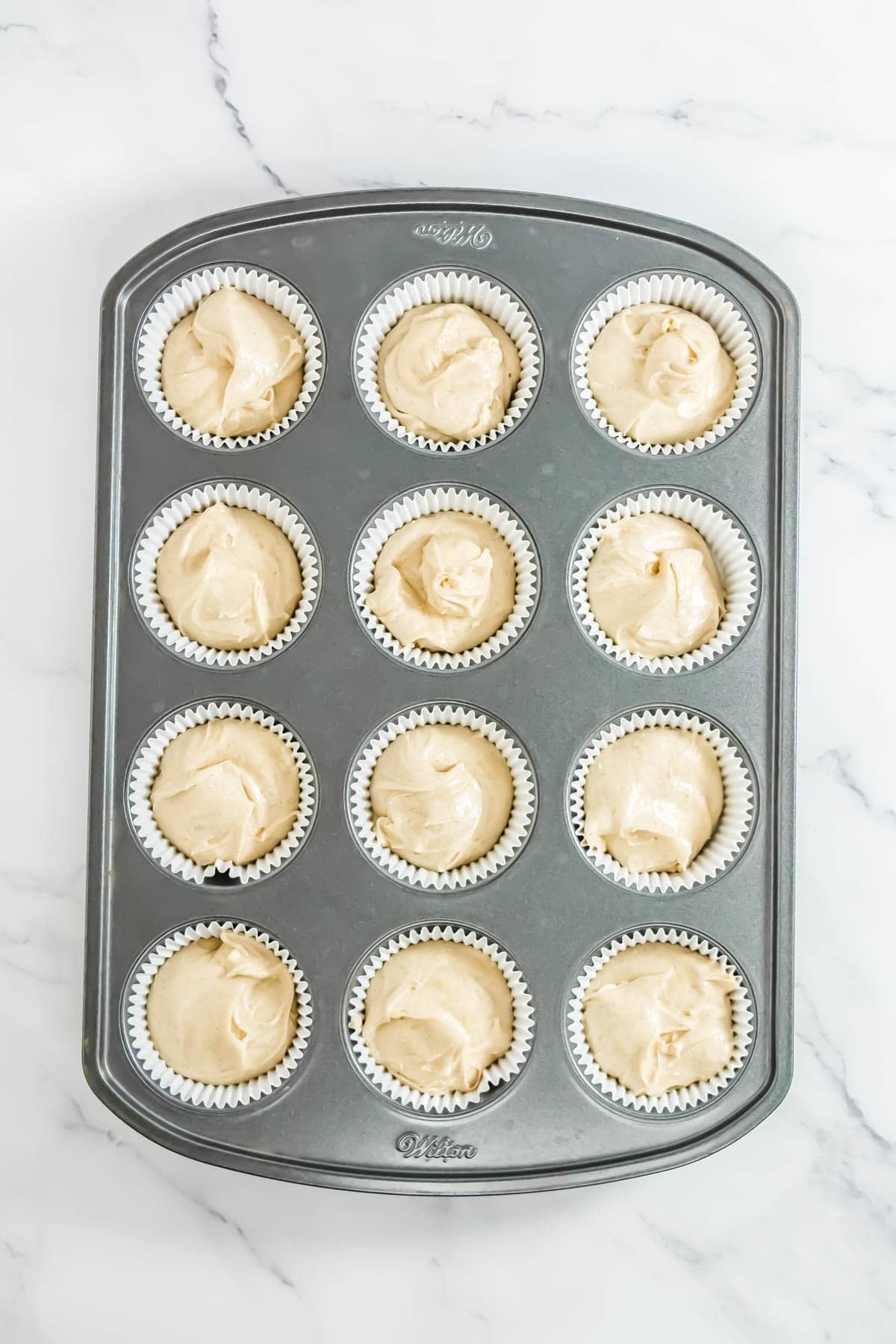 Cupcake batter divided equally between the lined cupcake tins.