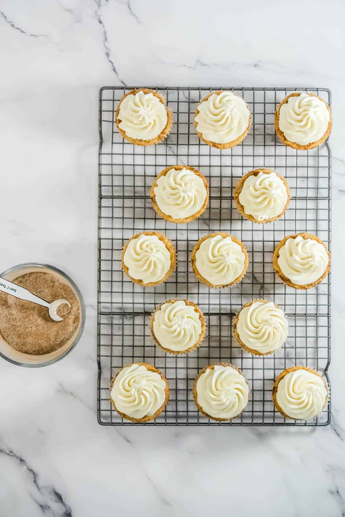 RumChata cupcakes topped with piped frosting on a wire rack.