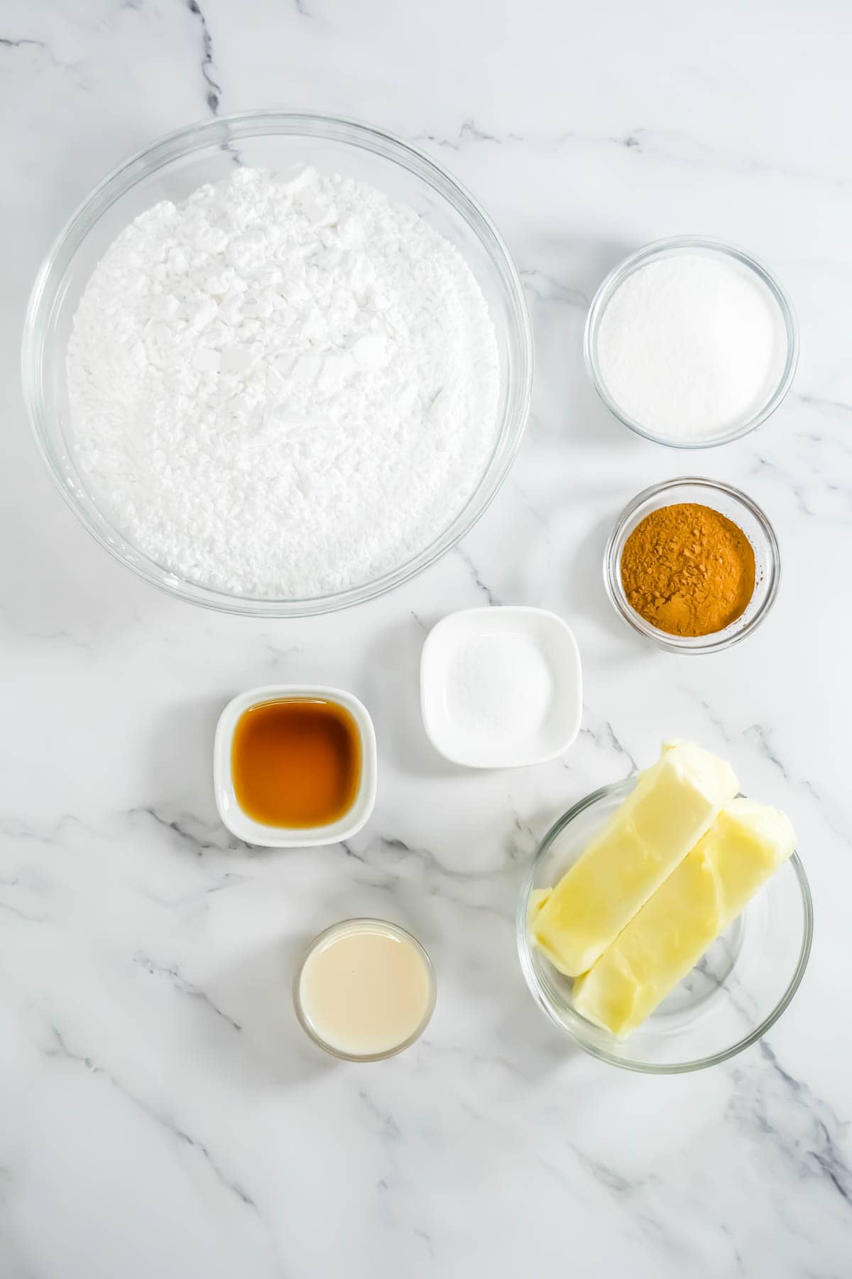 Ingredients for the RumChata cupcakes frosting on a white marble countertop.